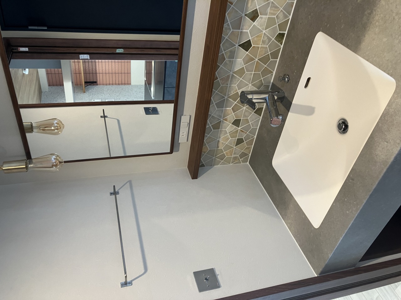 造作洗面台立ち上がりに石を貼りました。